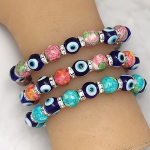 Detail of three-piece evil eye bead bracelets with colorful glass and crystal accents