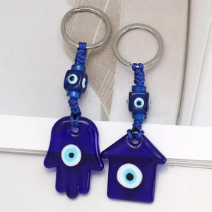 Detailed macro view of Turkish Evil Eye keychains with hand of Fatima and house charms
