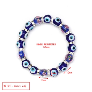 Close-up of blue evil eye beads and floral glass beads with silver spacers on a bracelet