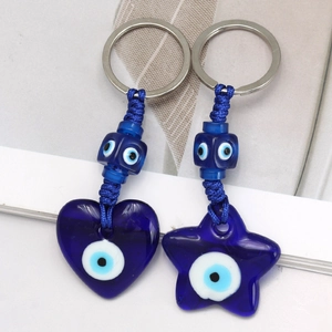 Macro detail of heart and star shaped blue Evil Eye pendants with braided rope keyring