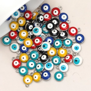 Macro detail of colorful Evil Eye enamel charms with silver metal edges and hooks