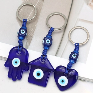 Three Turkish Evil Eye keychains in Hamsa, house and heart shapes with blue beads