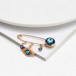 Detail einer goldenen Sicherheitsnadel-Brosche mit drei blauen Evil Eye Emaille-Anhängern