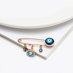 Detailansicht der Evil Eye Brosche mit blauen Emaille-Anhängern und goldener Nadel