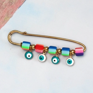 Close-up of colorful polymer clay evil eye safety pin brooch for clothing decoration