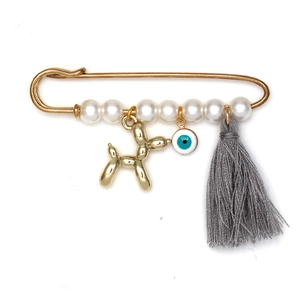Détail de la broche œil bleu avec breloque chien ballon doré et gland gris