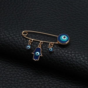 Detaillierte Brosche mit goldenem Auge des Bösen, Hand der Fatima und blauen Anhängern