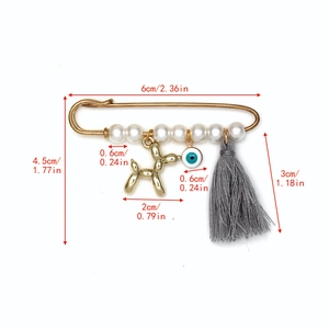 Détail d'une broche œil bleu avec pendentif chien ballon, perles et pompon gris