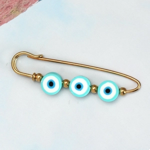 Detail of gold safety pin brooch with three blue evil eye beads and gold spacer beads