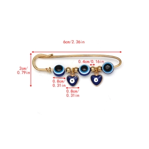 Detail van de gouden veiligheidsspeld broche met blauwe boze oog hart bedeltjes