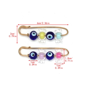 Detailed size view of evil eye and candy bead safety pins measuring 6cm in length