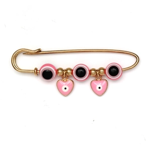 Detail van gouden veiligheidsspeld broche met roze boze oog kralen en hart hangers