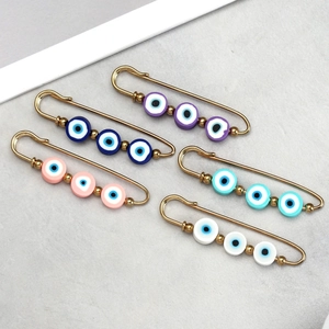 Detailed set of five colorful evil eye safety pins with gold-plated metal finish