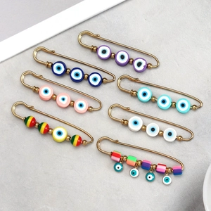 Set of seven gold safety pins with colorful Evil Eye beads in various styles