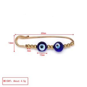 Detail view of Evil Eye safety pin brooch with 60mm length and gold-plated beads