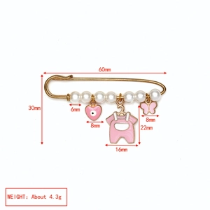 Détail de la broche épingle œil protecteur avec breloques cœur et papillon roses