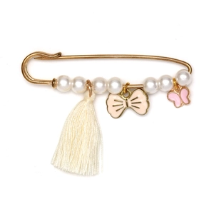 Détail d'une broche épingle dorée avec perles blanches, pompons et pendentif papillon
