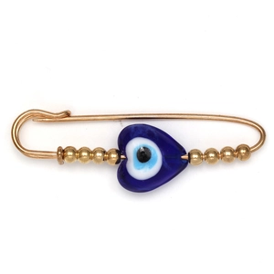 Macro shot of gold safety pin brooch featuring a blue heart-shaped evil eye and gold beads