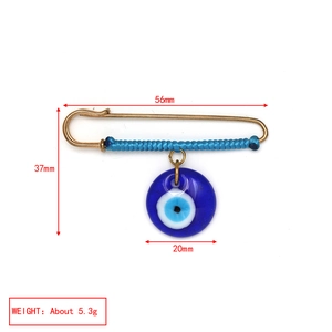 Detail view of Evil Eye brooch with dimensions 56mm by 37mm on white background