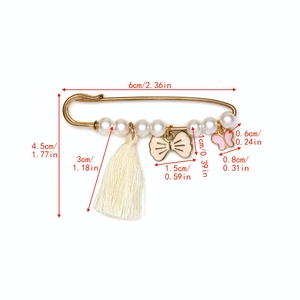 Détail de la broche œil bleu avec perles et pompon montrant les dimensions réelles