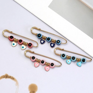 Modieuze boze oog veiligheidsspeld broches in goud met hart- en kralenhangers