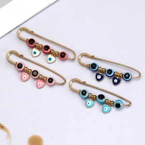 Detailweergave van kleurrijke boze oog veiligheidsspeld broches met hartjes in goud