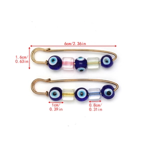 Detailed view of evil eye safety pin brooch with 6cm measurement line and blue beads