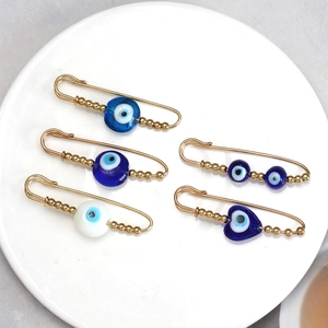 5-piece set of golden Evil Eye safety pin brooches featuring blue resin beads and charms