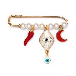 Détail de la broche épingle dorée avec perles blanches et pendentifs œil et piment