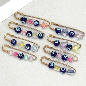 Set of 8 gold safety pin brooches with evil eye beads and colorful acrylic candy charms