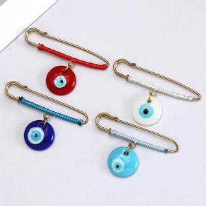 Detailed view of colorful evil eye safety pins with decorative woven silk threads