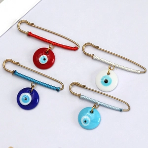 Set of four evil eye safety pins featuring colorful woven cord and glass eye pendants