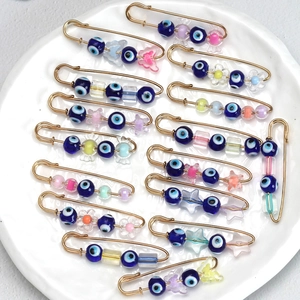 Macro detail of Turkish Evil Eye brooches with colorful candy-style beads and gold pins