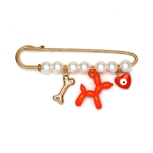 Détail de la broche épingle dorée avec perles, chien ballon et pendentif œil maléfique