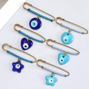 Detail of evil eye safety pin set featuring star heart and round glass charms