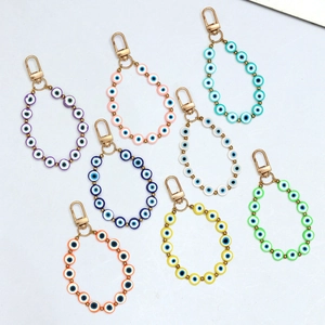 Detailed view of colorful Evil Eye beaded charms with gold lobster clasps in various shades