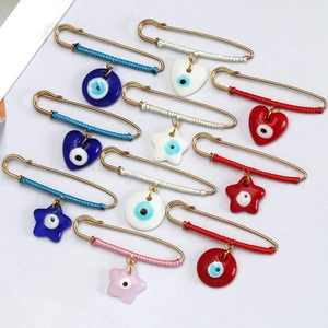 Detailed close-up of 11-piece gold evil eye brooch set with colorful woven thread and charms