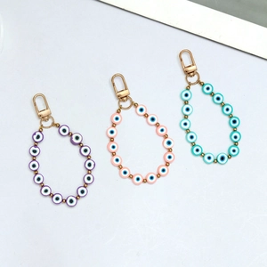 Detailed view of Evil Eye beaded keychains in purple, pink, and blue with gold clasps