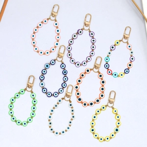 Detail of eight colorful Evil Eye keychains with gold lobster clasps in various vibrant shades