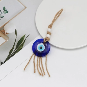 Detail of blue glass Evil Eye pendant with natural hemp rope tassel and beads