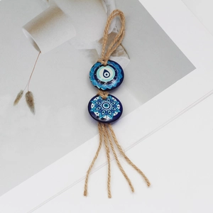 Close-up of blue Evil Eye beads with mandala patterns and rustic hemp rope tassels