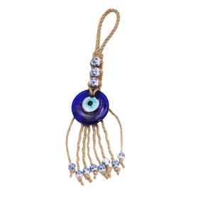 Detail of Turkish evil eye glass pendant with jute rope and floral ceramic beads