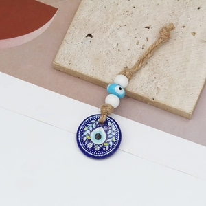 Detailed macro view of the handcrafted blue evil eye charm with rustic hemp rope textures