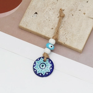 Detail of Turkish Nazar evil eye pendant with blue mandala pattern and rustic hemp rope
