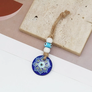 Detailed close-up of blue Turkish Evil Eye glass pendant with rustic hemp rope and beads