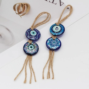 Detailed macro view of two blue Evil Eye beaded charms with rustic hemp rope and tassels