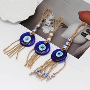 Close-up of three Evil Eye hanging ornaments with jute ropes and ceramic beads