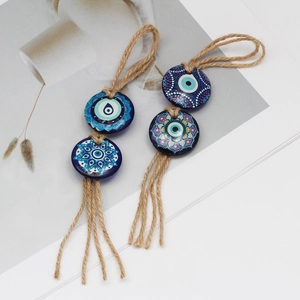 Detail of blue evil eye wall hanging decor with hemp rope and mandala tassels
