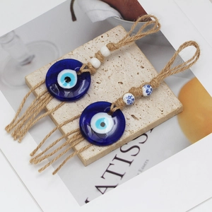 Detail of blue glass Evil Eye charms with jute rope tassels and patterned ceramic beads