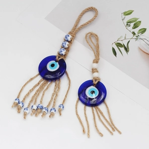 Macro detail of Evil Eye pendant with blue glass charm, jute rope, and decorative beads